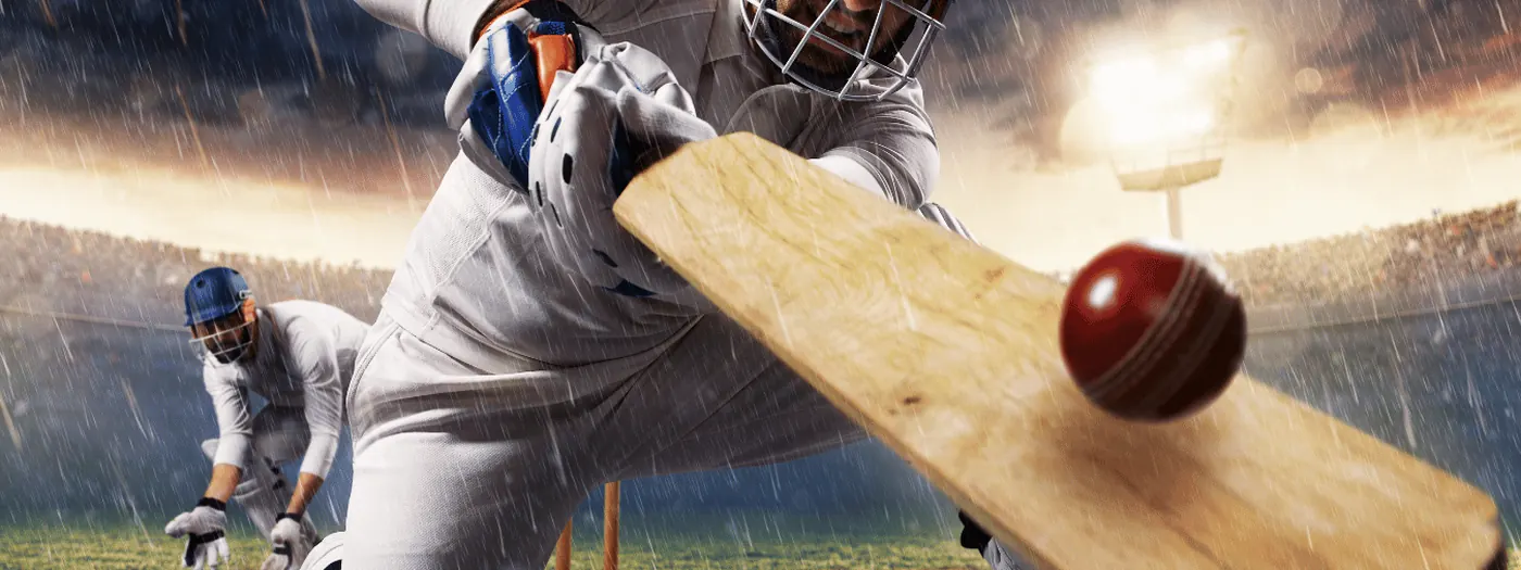 A batsman driving through the line under lights in the rain