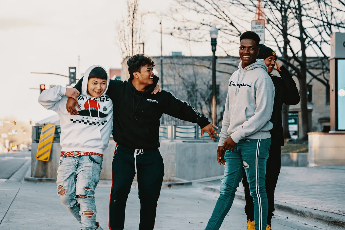 A group of mates in tracksuits and streetwear on a city street