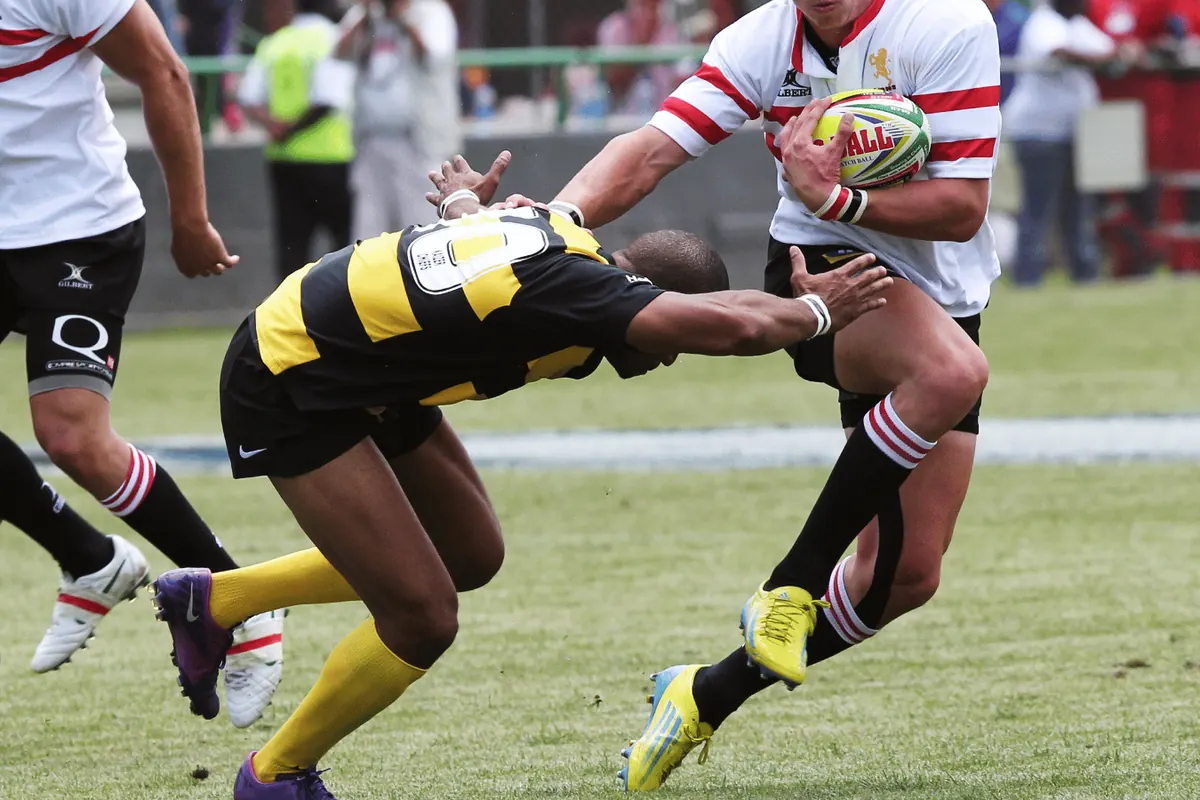 A rugby league player being tackled while carrying the ball